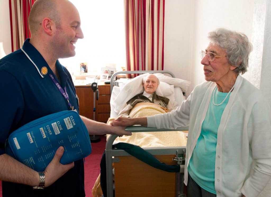 A district nurse chats with an elderly carer