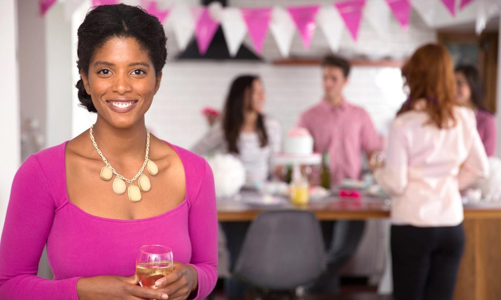An attractive woman in pink hosts a fundraising party