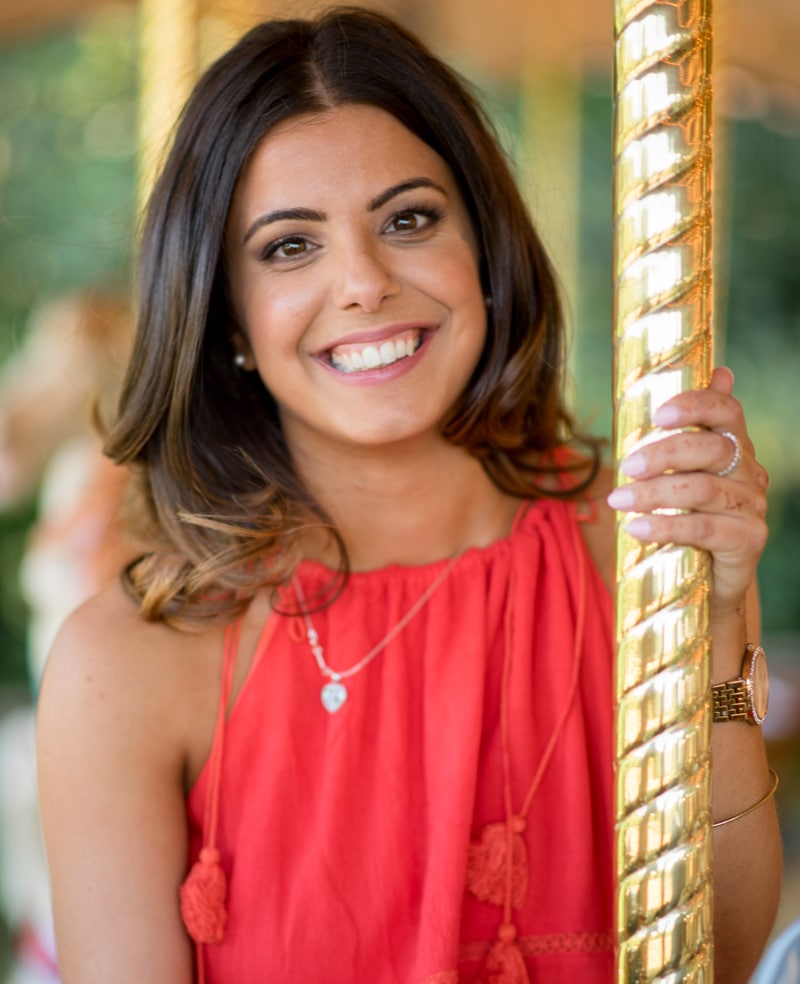 Portrait of a young woman wearing red on a merry-go-round