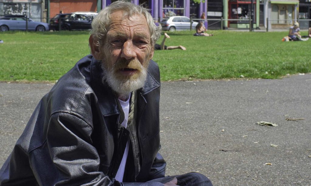 Homeless man sitting in a park
