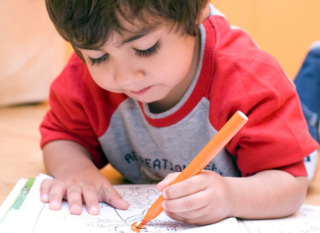 A young toddler drawing with a pencil