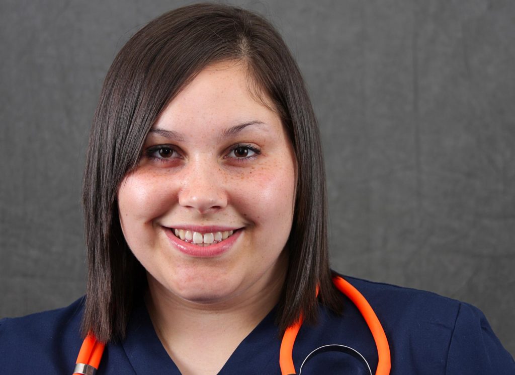A young student nurse in blue uniform smiling