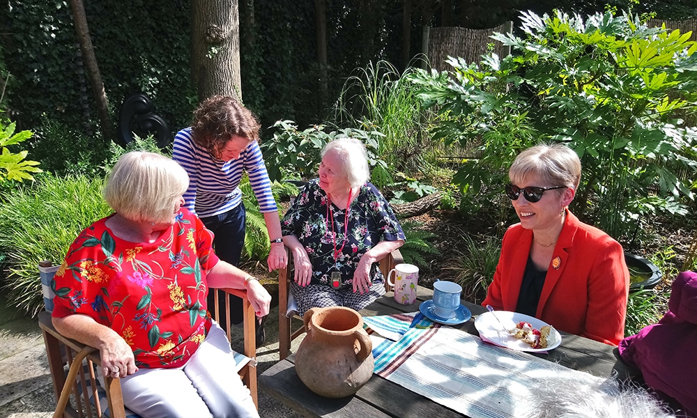 Four women drinking tea in the garden
