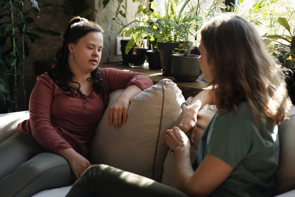 Two women sitting on a couch chatting