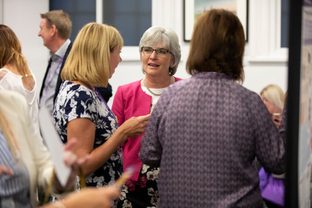 A group of people talking at a QNI event